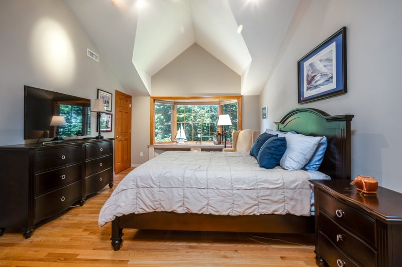 Primary Bedroom with hardwood floors, walk-in closet, multiple windows with seasonal Hudson River views and high vaulted ceiling.