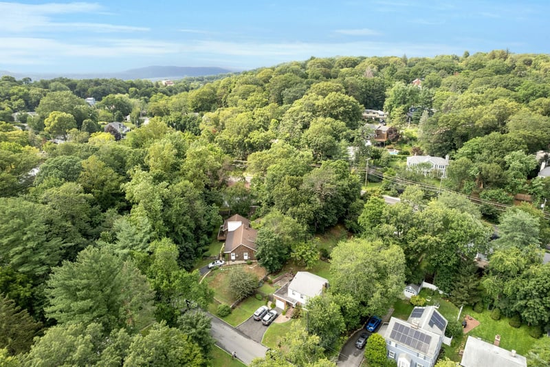 Aerial view of property and surrounding area featuring a heavily wooded area