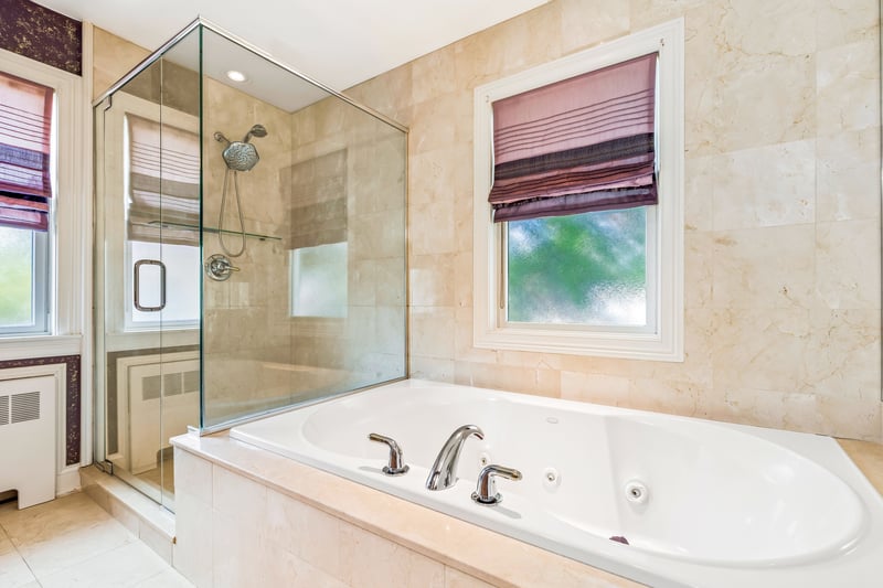 Primary bath has a jacuzzi tub and glass enclosed shower