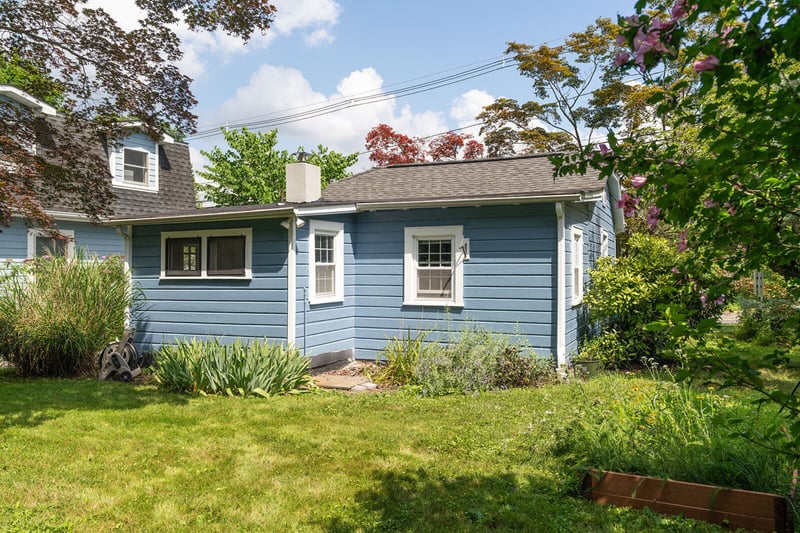Back of property featuring a lawn and a shingled roof