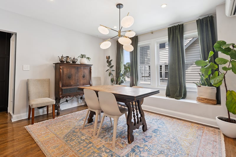 Dining space featuring a wall unit AC, a chandelier, wood finished floors, and recessed lighting...