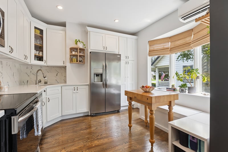 Kitchen featuring stainless steel appliances, light countertops, dark wood-style floors, recessed lighting, and white cabinets...