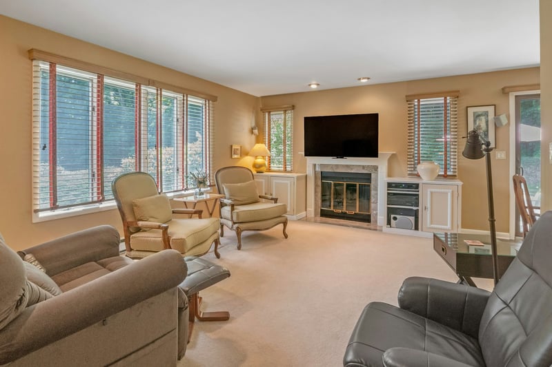 Carpeted living room featuring a fireplace and built-ins