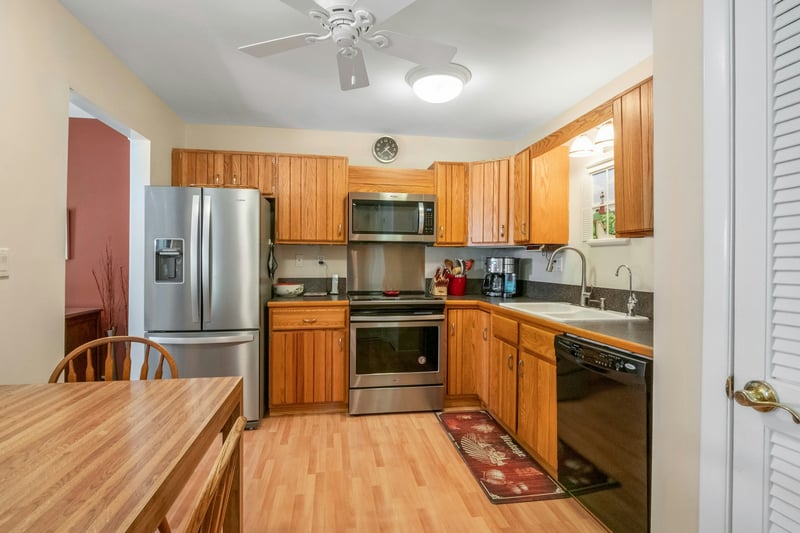 Kitchen with stainless steel and black appliances, hardwood floors and maple cabinets