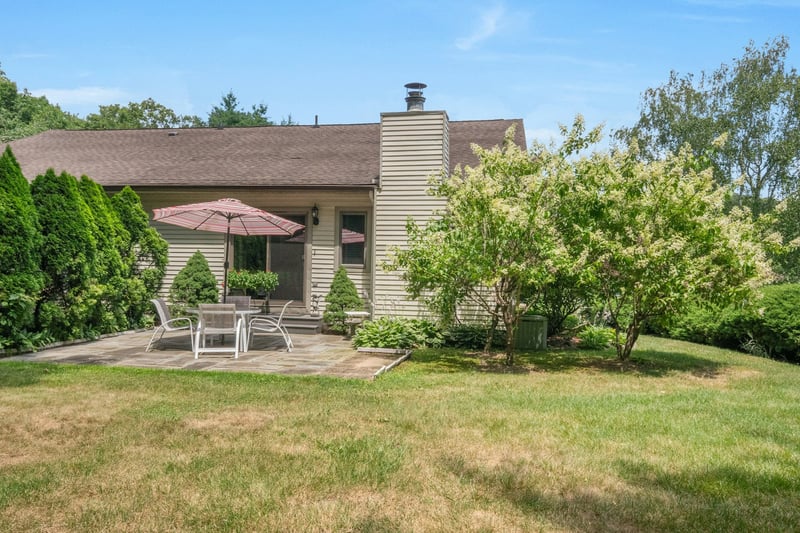 Rear view of property featuring a patio area and plenty of lawn space