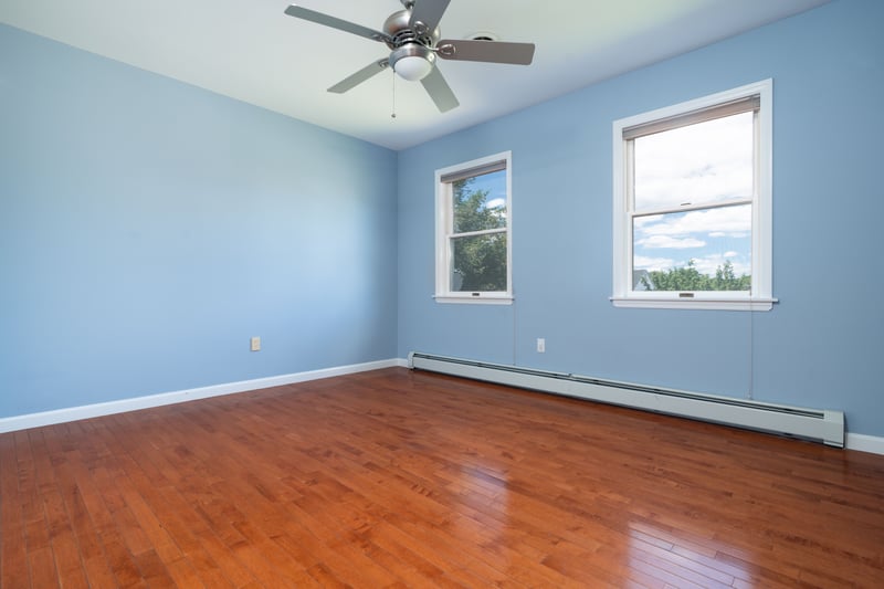 Spare room with baseboard heating, hardwood / wood-style floors, and a ceiling fan