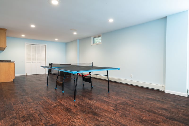 Recreation room with wood-style floors, recessed lighting, and a baseboard heating unit