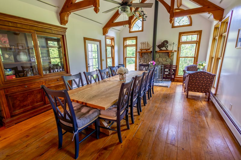 Dining room featuring a baseboard heating unit, beamed ceiling, wood-type flooring, a ceiling fan, and high vaulted ceiling