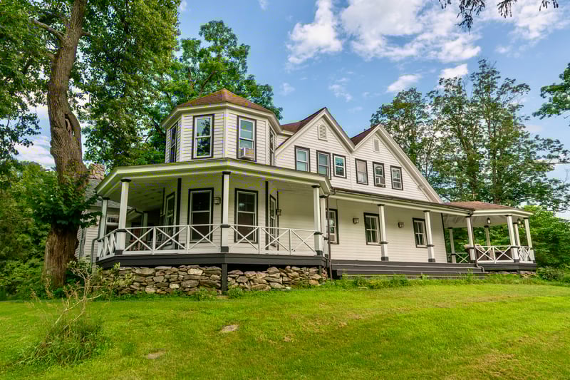 View of front facade with covered porch and a front yard