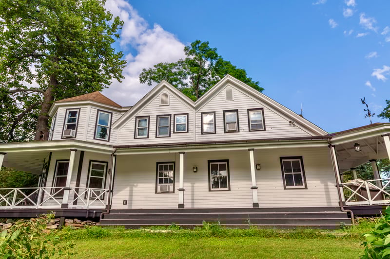 Farmhouse-style home with covered porch and a front yard