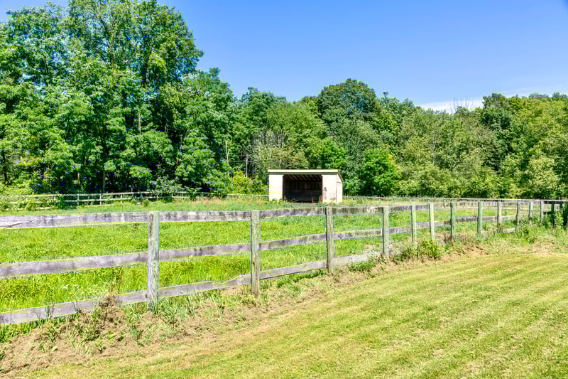 View of yard featuring a rural view, an outdoor structure, a forest view, and a pole building