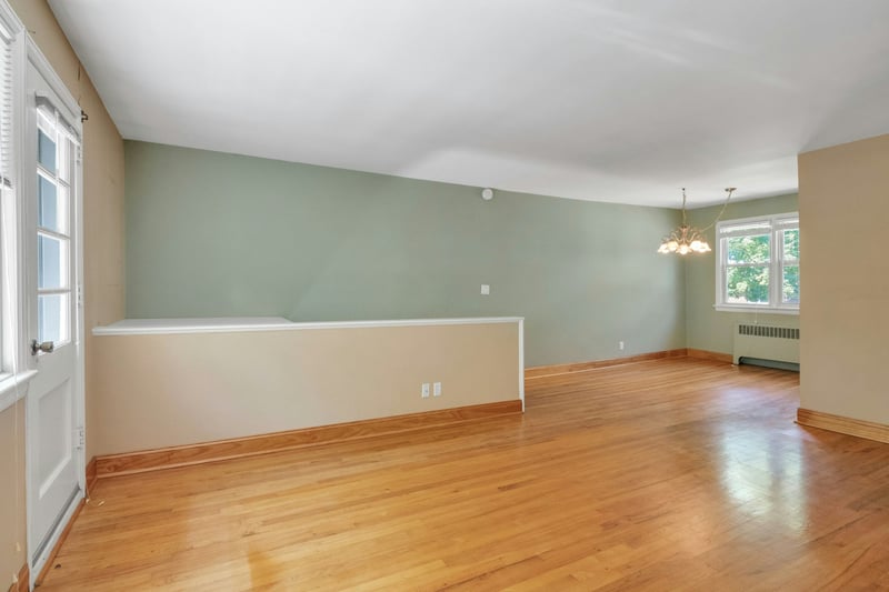 Living room with hardwood floors, open to the dining area.