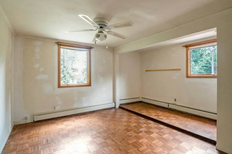 Unfurnished room featuring a baseboard radiator, plenty of natural light, and a ceiling fan...