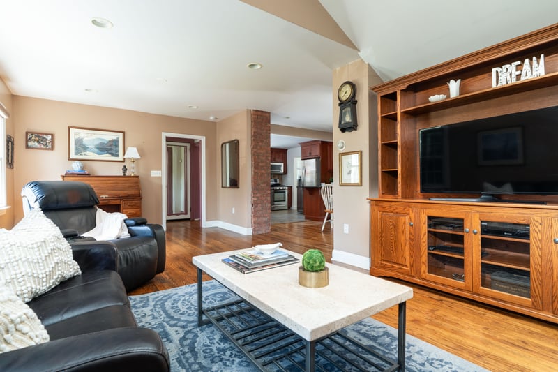 Living area featuring light wood-style flooring, lofted ceiling, and recessed lighting