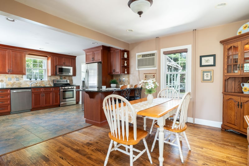 Dining area with light wood-style floors, recessed lighting, and an AC wall unit