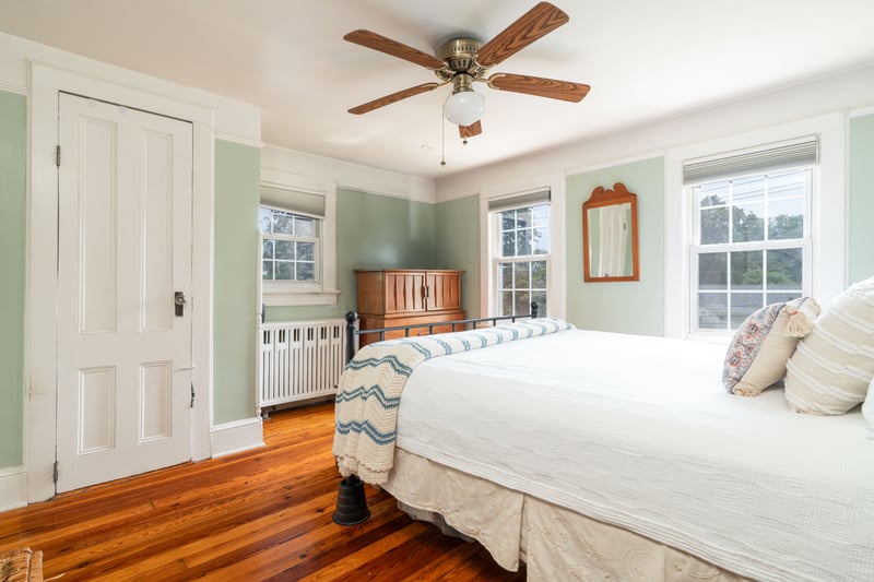 Bedroom featuring radiator, wood finished floors, and a ceiling fan