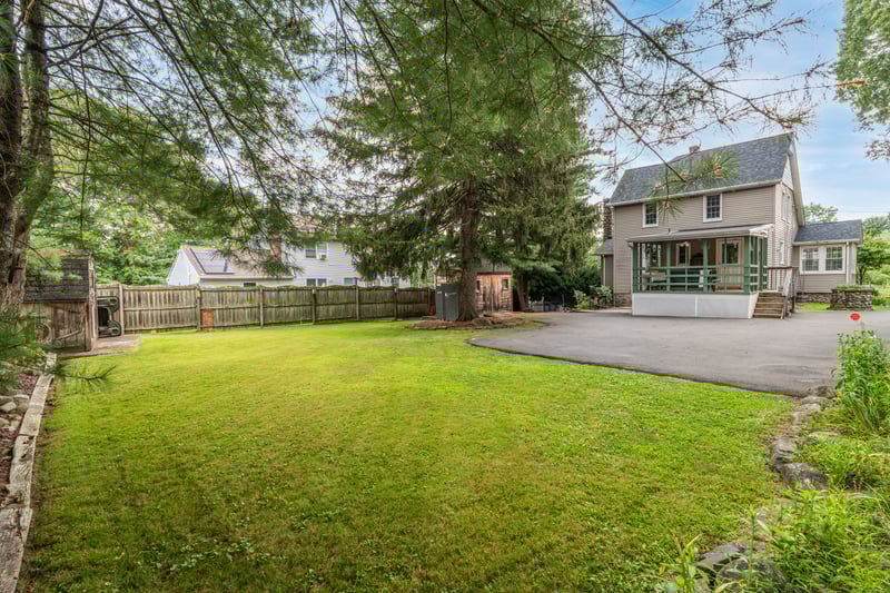 Fenced backyard featuring a sunroom