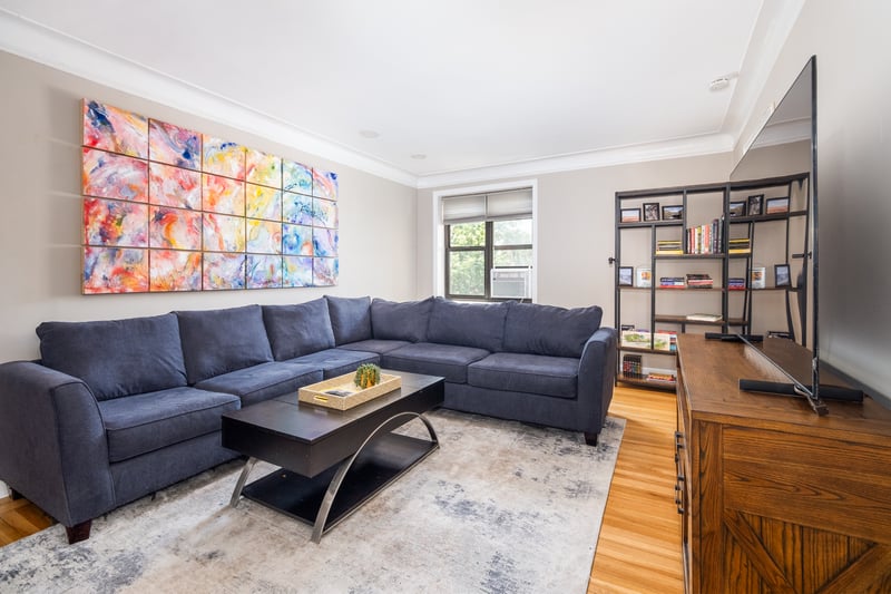 Living room with crown molding and wood finished floors