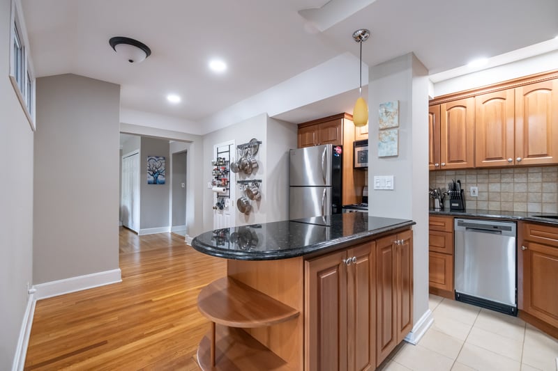 Kitchen featuring open shelves, decorative backsplash, appliances with stainless steel finishes, a kitchen island, and hanging light fixtures