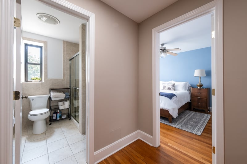 Adjacent 2nd Full bath with a shower stall, wood finished floors, a ceiling fan, and tile walls