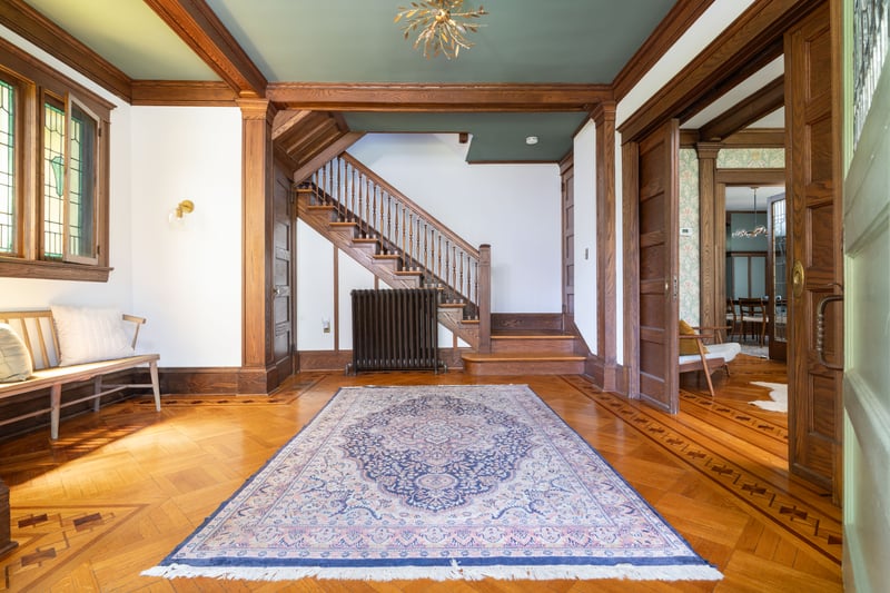 Entryway with a chandelier, radiator and moldings