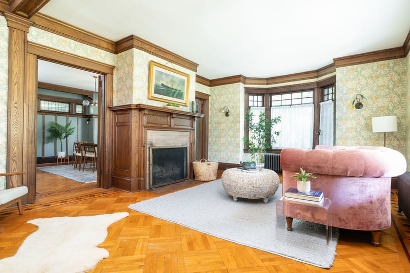 Living room featuring wallpapered walls, ornamental molding, a fireplace with flush hearth, and radiator heating unit