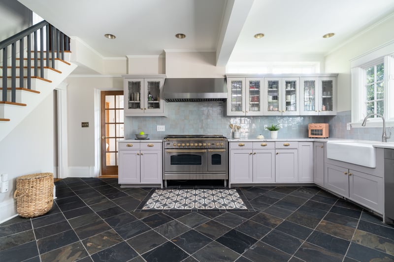 Kitchen with crown molding, high end stainless steel range, decorative backsplash, wall chimney range hood, and glass insert cabinets