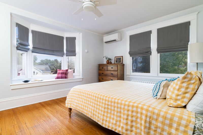 Bedroom with ornamental molding, hardwood / wood-style flooring, ceiling fan, and a wall mounted AC