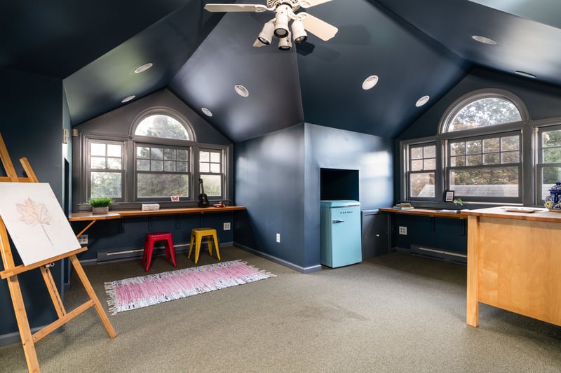 Recreation room featuring an office area, carpet floors, vaulted ceiling, a baseboard heating unit, and ceiling fan