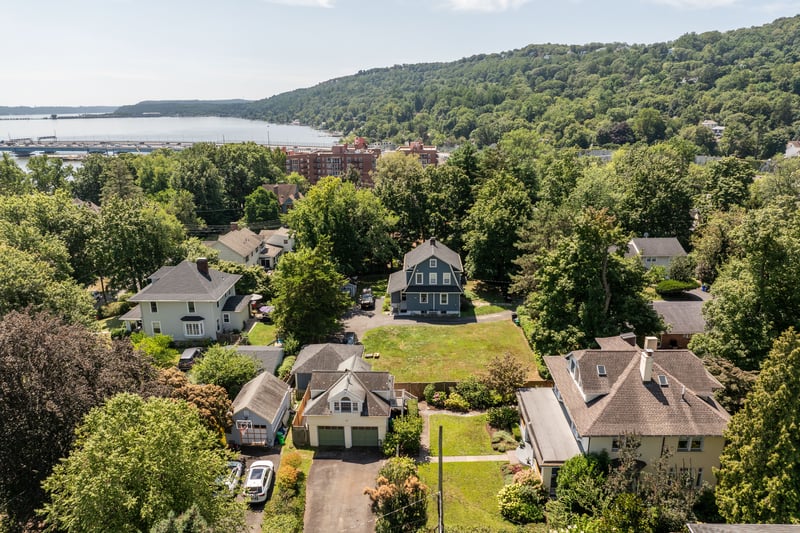 Aerial perspective of suburban area with a large body of water and a heavily wooded area