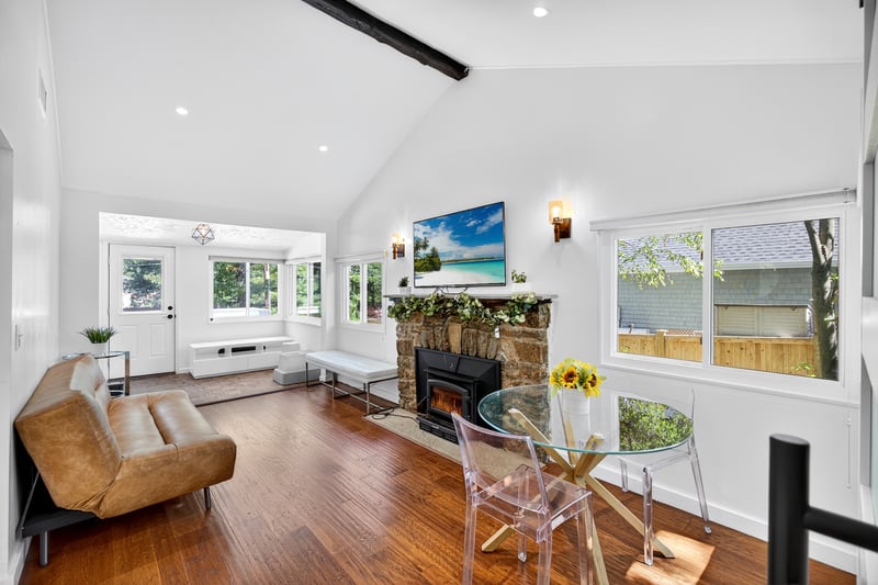 Living room featuring beam ceiling, high vaulted ceiling, wood finished floors, recessed lighting, and plenty of natural light