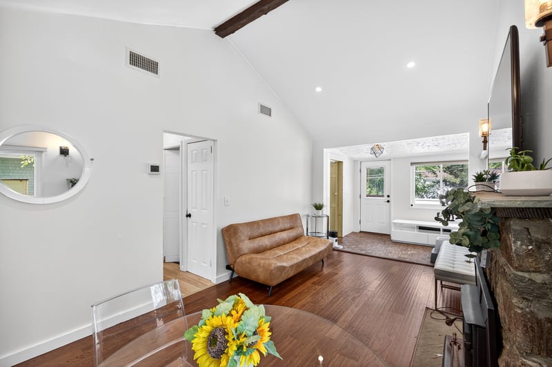 Living area with beamed ceiling, wood finished floors, high vaulted ceiling, and recessed lighting