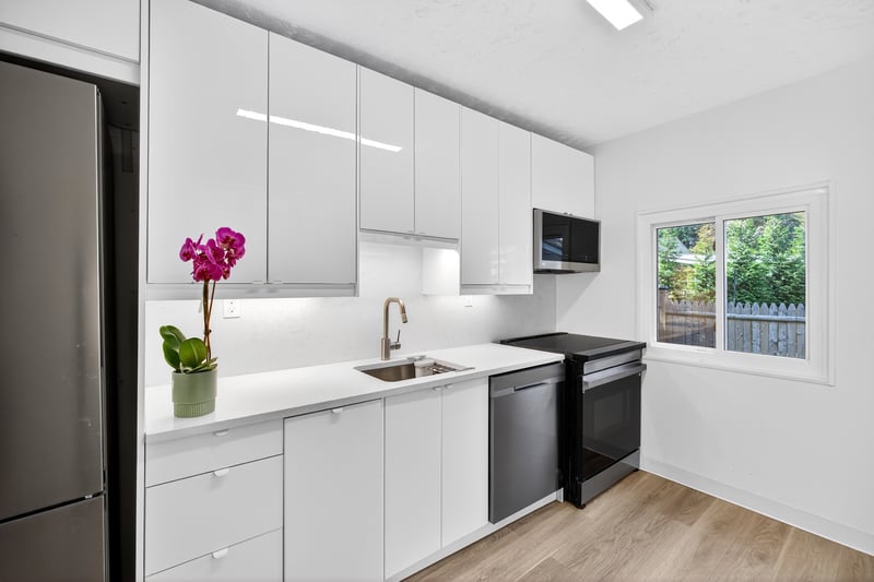 Brand New Kitchen with modern cabinets, Quartz Counters, stainless steel appliances, white cabinetry, light wood-style floors, and a textured ceiling