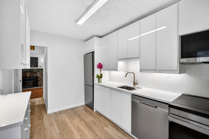Brand New Kitchen with modern cabinets, Quartz Counters, stainless steel appliances, white cabinetry, light wood-style floors, and a textured ceiling