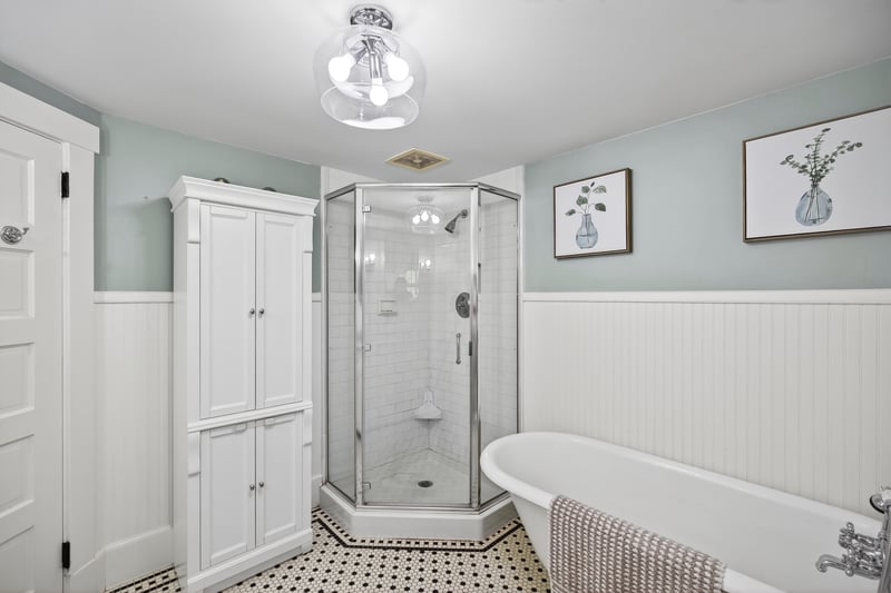 Bathroom with wainscoting, a shower stall, and a freestanding tub
