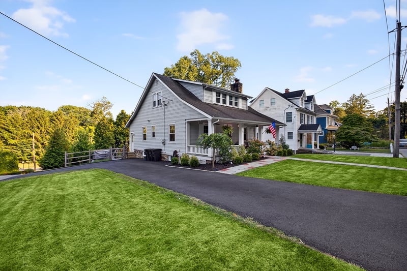 View of front and side of property featuring a porch, and front yard.