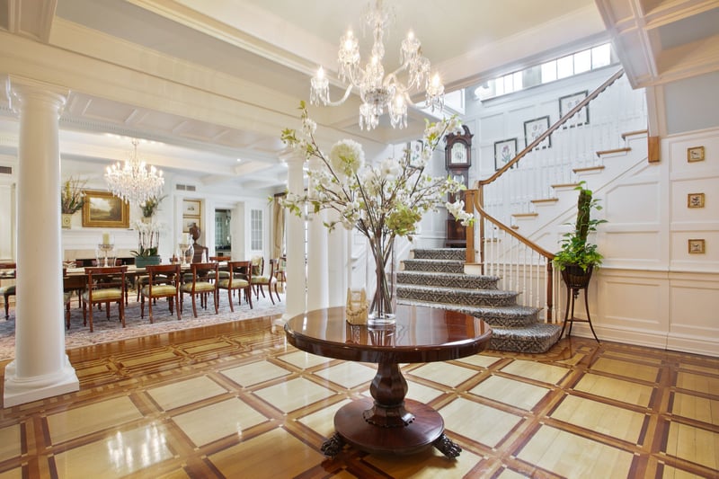 Enter through the gracious double column foyer with custom painted hardwood floors and custom plaster moldings.