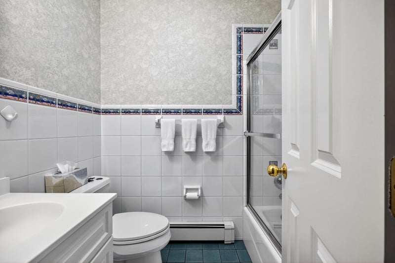 Full bath with shower / bath combination with glass door.