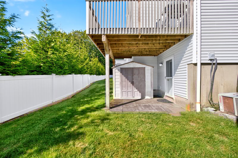 View of the back with a storage shed, patio, and deck.