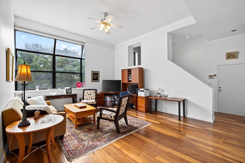 Office area with wood finished floors, a ceiling fan, and crown molding...