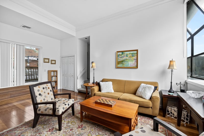Living room featuring hardwood / wood-style flooring, crown molding, and stairs...