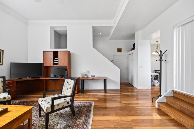 Living area featuring , hardwood / wood-style flooring, crown molding, and stairs leading to deck