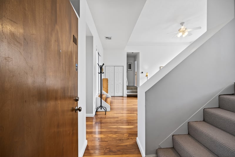 Entrance foyer featuring stairway, wood finished floors, and a ceiling fan