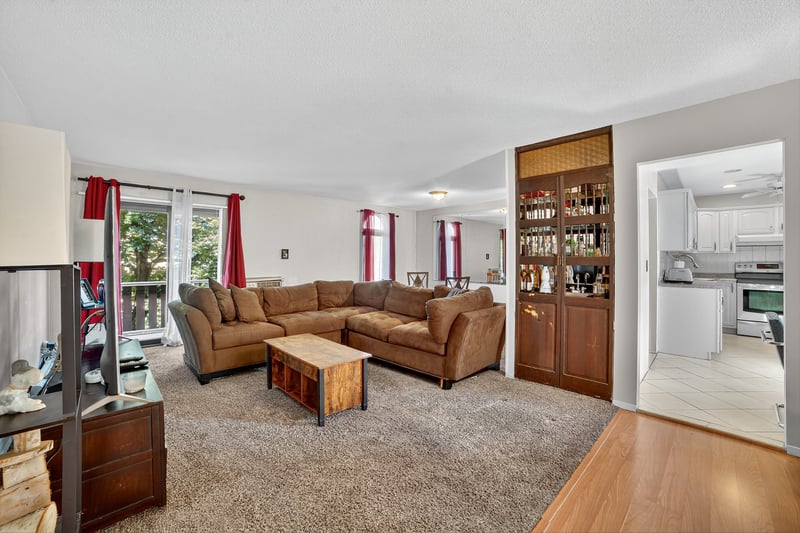 Living room with light wood-type flooring and light carpet