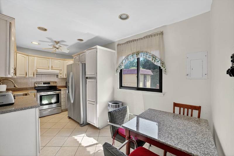 Kitchen with stainless steel appliances, light tile patterned flooring, decorative backsplash, recessed lighting, and electric panel