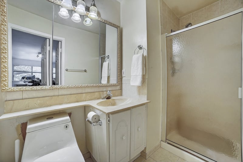 Bathroom featuring a shower stall, vanity, and light tile patterned floors