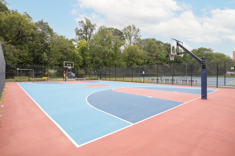 View of sport court featuring community basketball court and view of wooded area