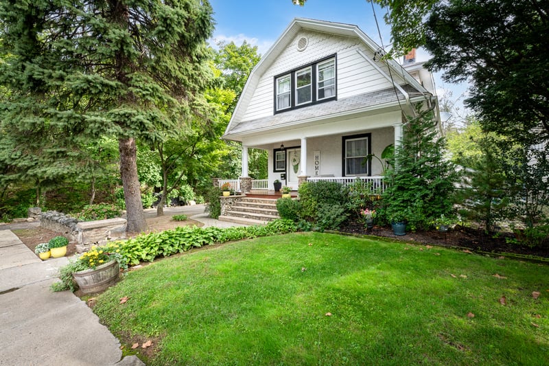 Dreamy gambrel roof, wraparound porch, and front lawn.