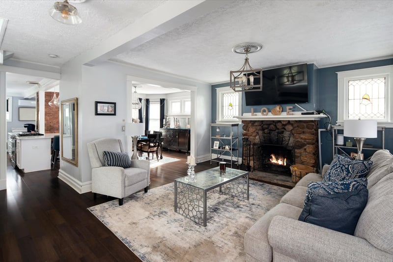 Come sit a while! Living room featuring wood burning fireplace and stained glass windows.