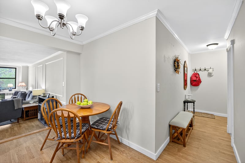 Dining space featuring light wood-style flooring, ornamental molding, and a chandelier